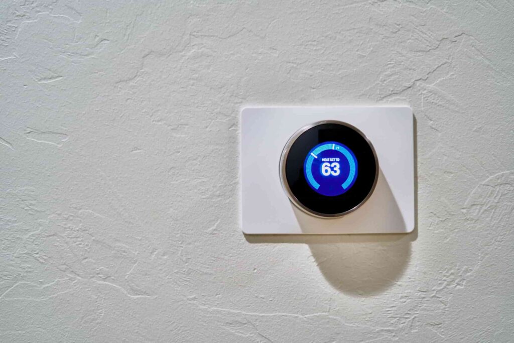 save money with a thermostat; a modern thermostat on a plain white wall